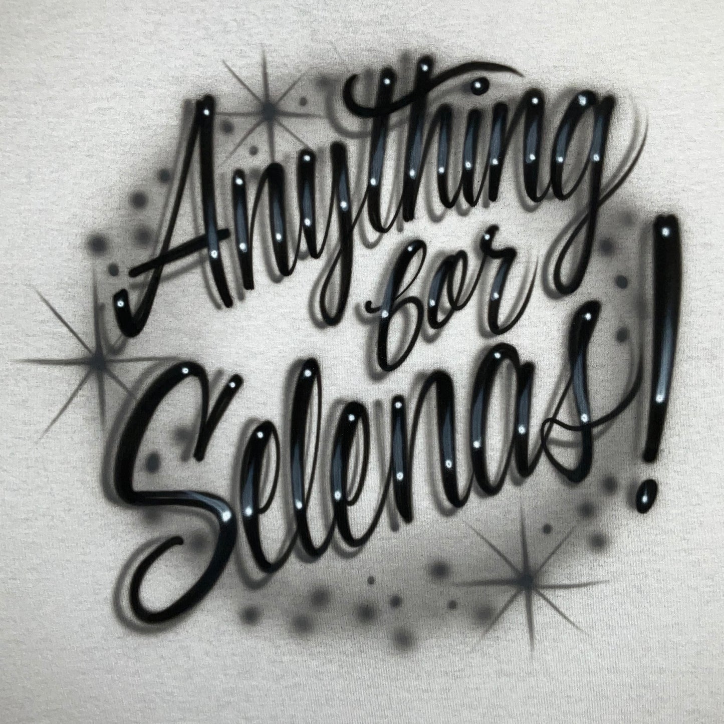 Hand-airbrushed Anything for Selena shirt with flowing script lettering, glow effects, and starburst accents, fan-inspired artwork by Fresh Air Shirts