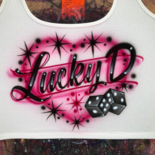 Hand airbrushed Lucky dice design with glossy black dice, fuchsia glow, and black starburst accents on white apparel.
