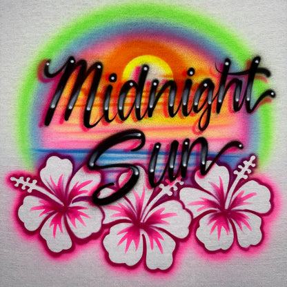Airbrushed Midnight Sun shirt with beach sunset and hibiscus flowers, fan-inspired handmade design evoking endless summer