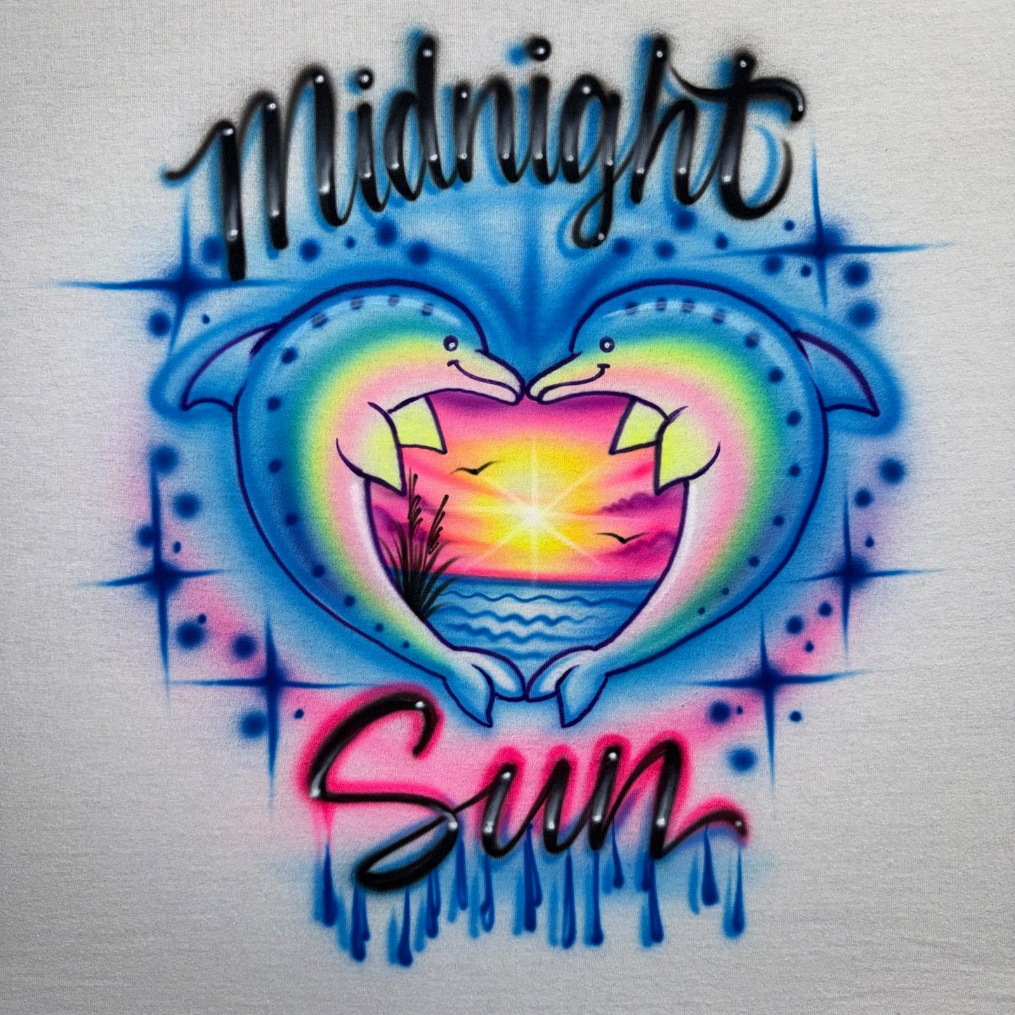 Hand airbrushed Midnight Sun dolphin heart sunset design with ocean and drippy lettering on white shirt
