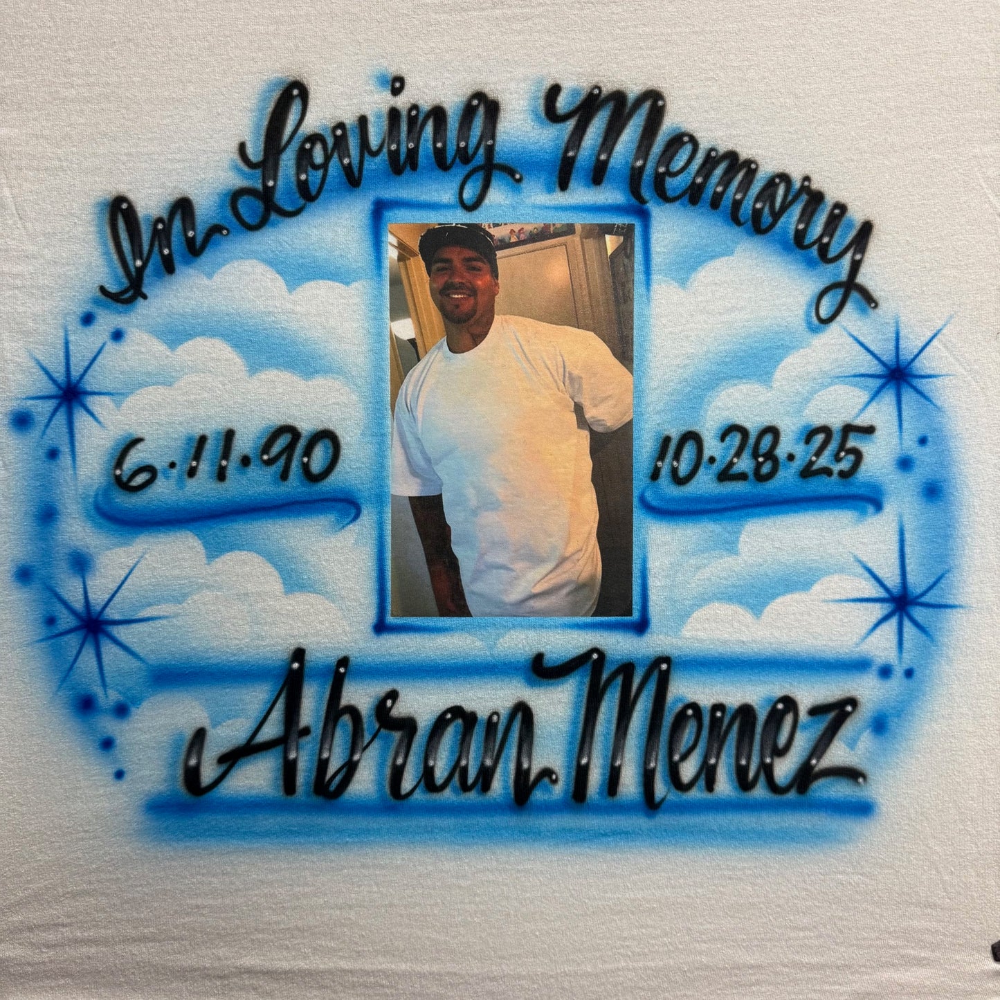 Airbrushed memorial shirt with clouds, stars, custom name, dates, and a photo transfer in the center.