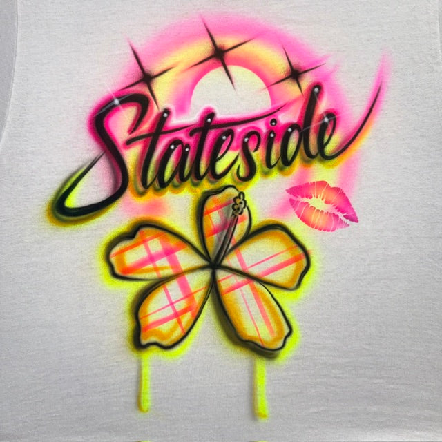Hand-airbrushed Stateside shirt with colorful plaid flower, pink kiss lips, black script lettering and neon starburst accents